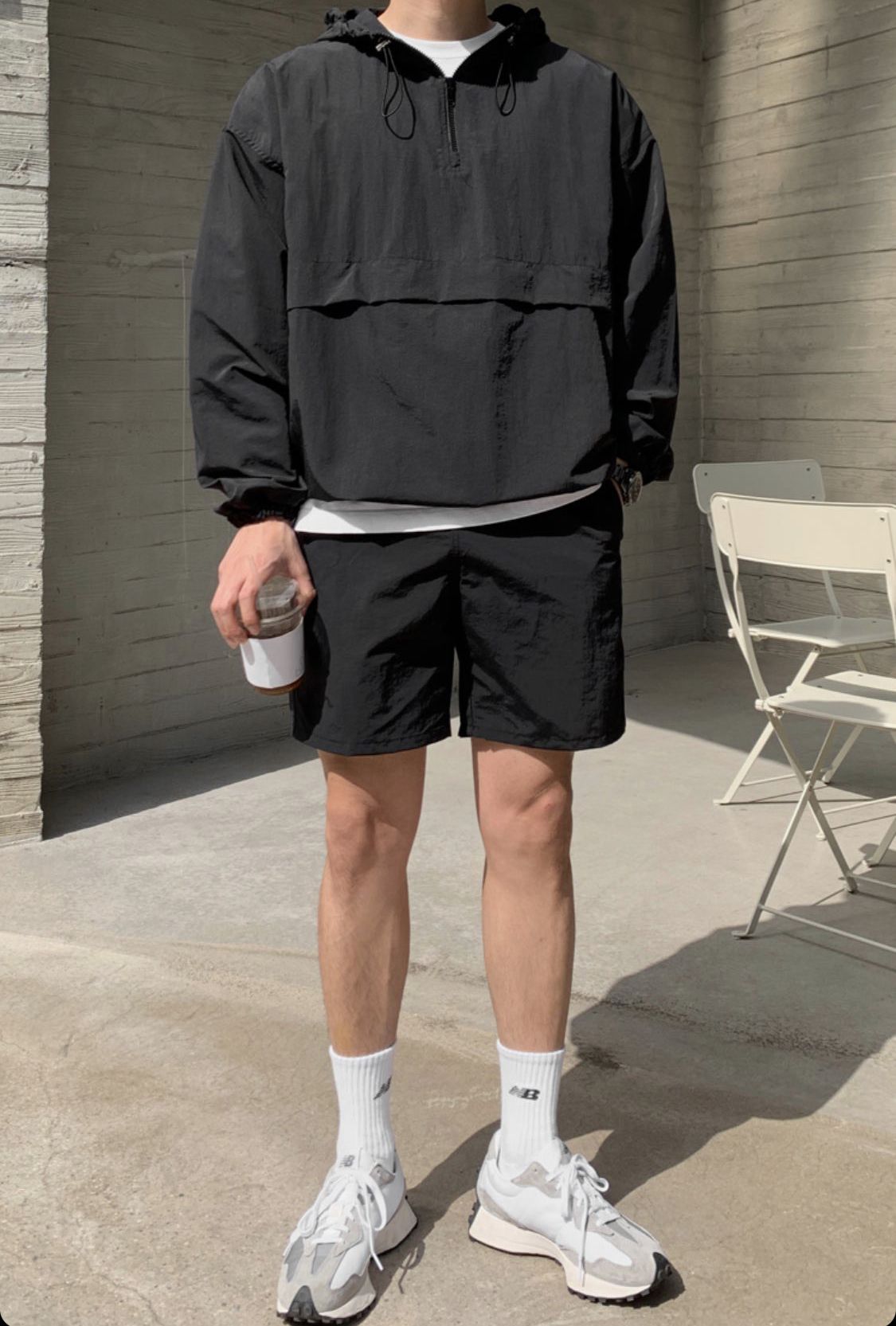 블랙 아노락 점퍼와 나일론 쇼츠를 입은 남성 착장